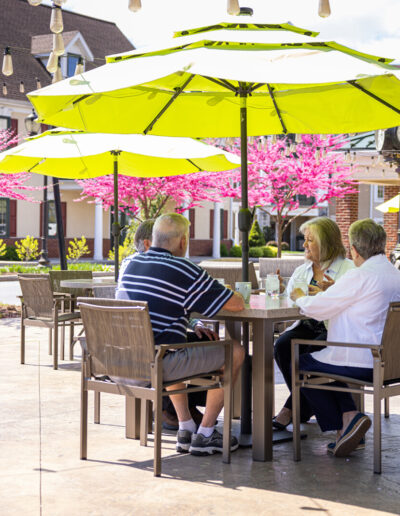 A group of retirees enjoys the shaded patio.