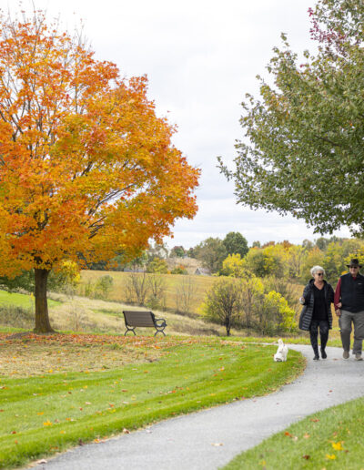 Couple walks through beautiful fall scenery at Pleasant View Retirement Community.